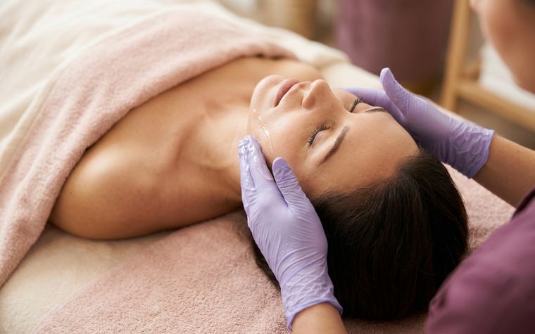 Esthetician cleansing a client’s face during a Purifying facial at Bare Skin Waxing in Alexandria