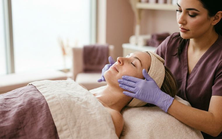 Esthetician performing a lifting facial massage along the jawline