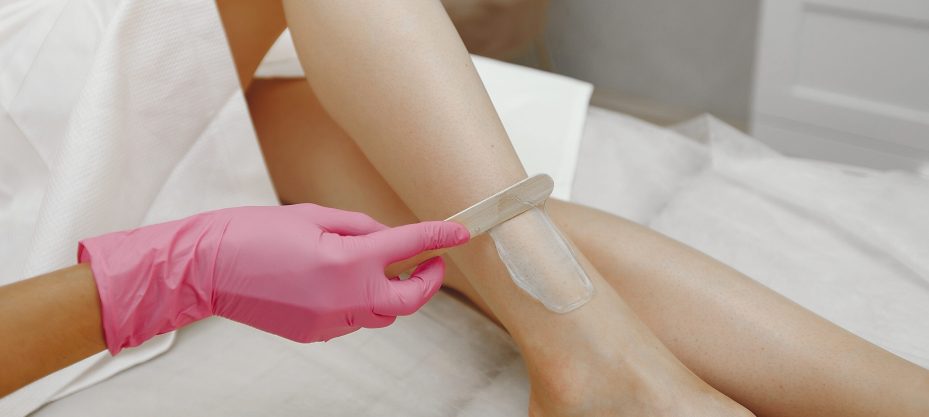 Hair removal. Gel for laser. Woman in a pink gloves.