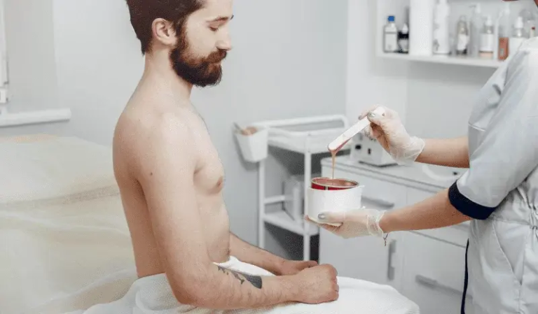 Male client with an esthetician preparing hard wax in a private treatment room at Bare Skin